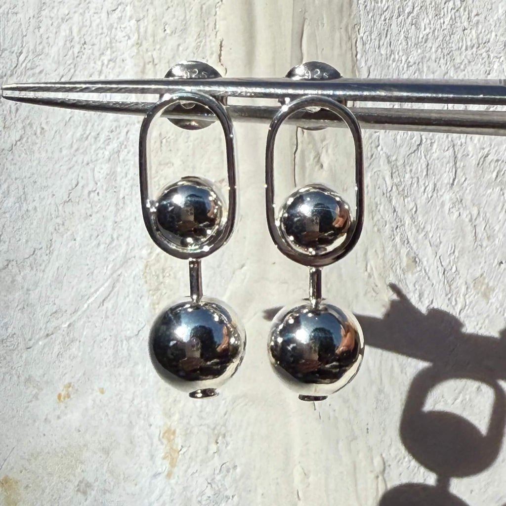 Silver stud earrings with spherical beads on a white background