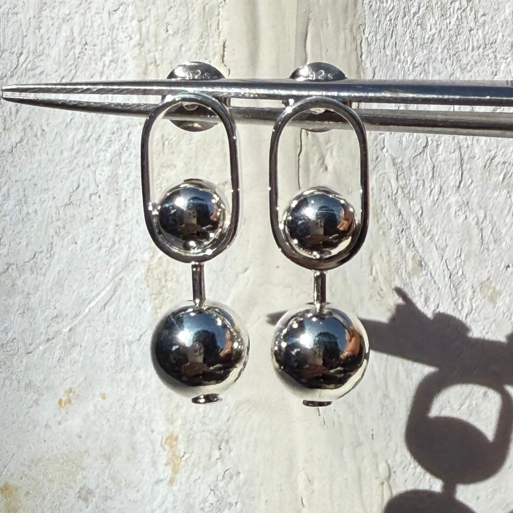 Silver stud earrings with spherical beads on a white background