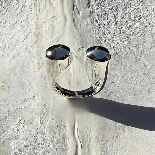 Silver ring with black stones on a textured white surface