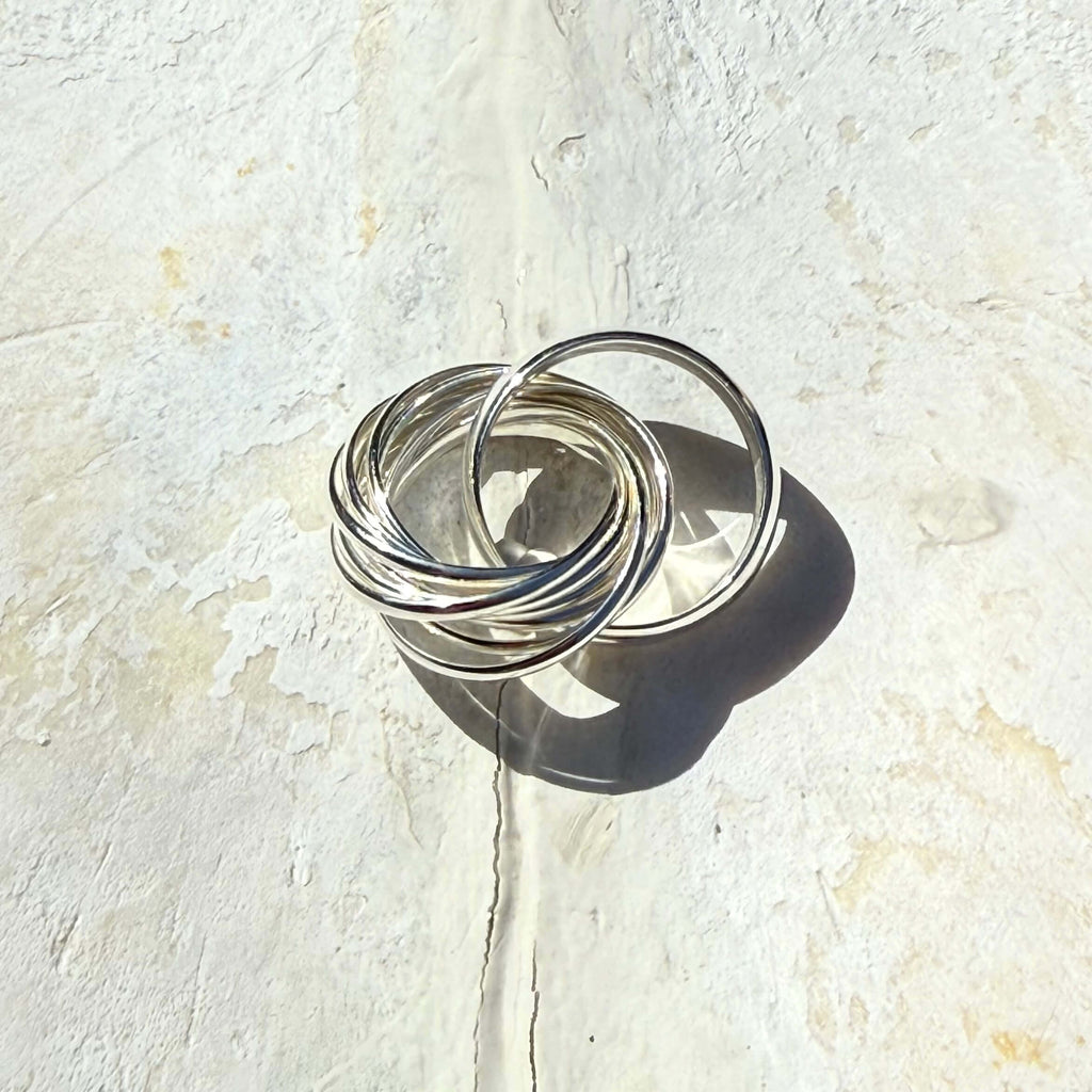 Silver rings stacked on a textured white surface