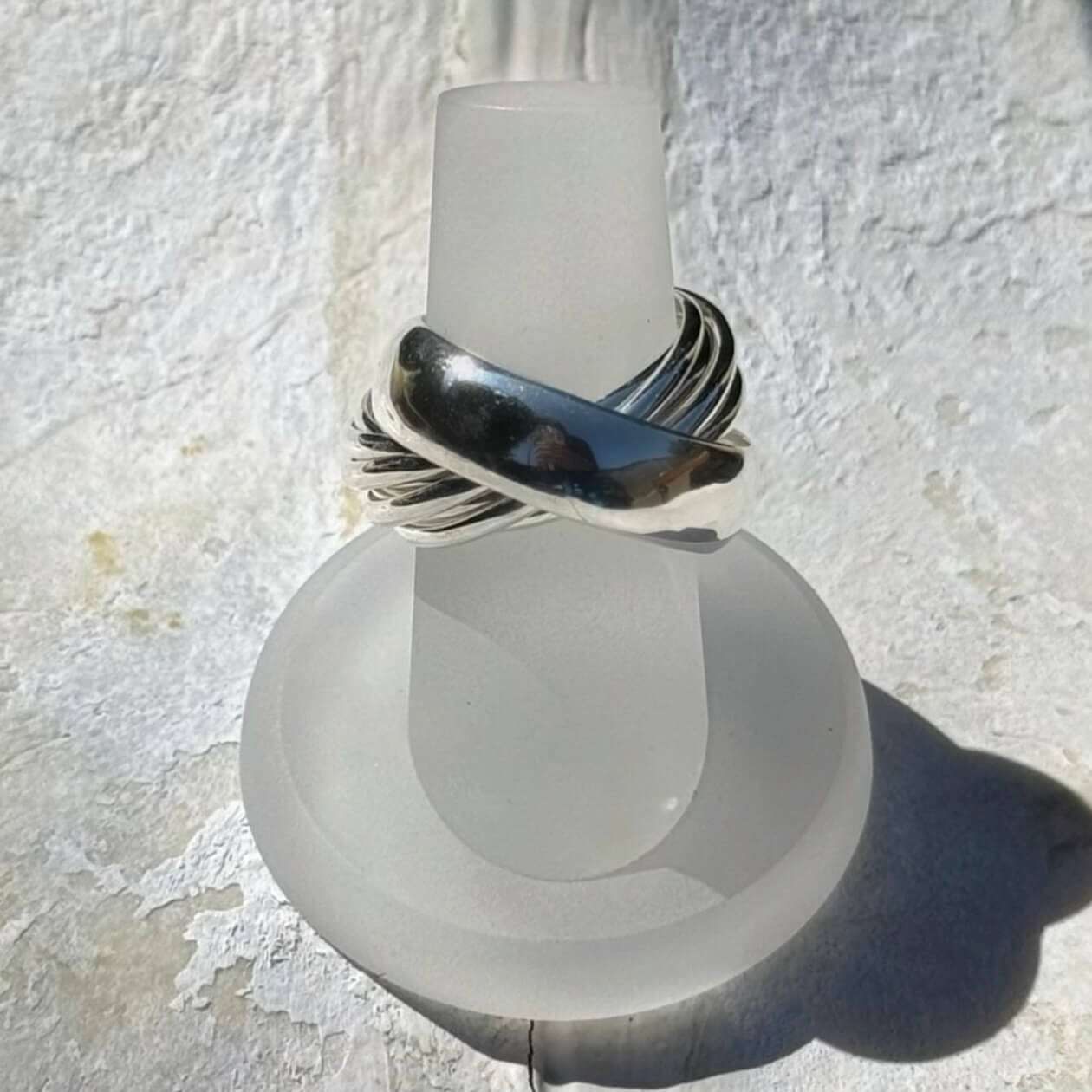 Silver ring on a white light bulb against a textured white background