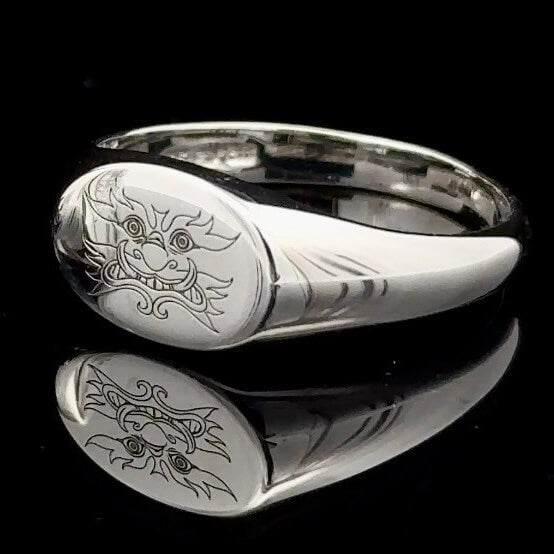 Oval yak signet silver ring on a black background