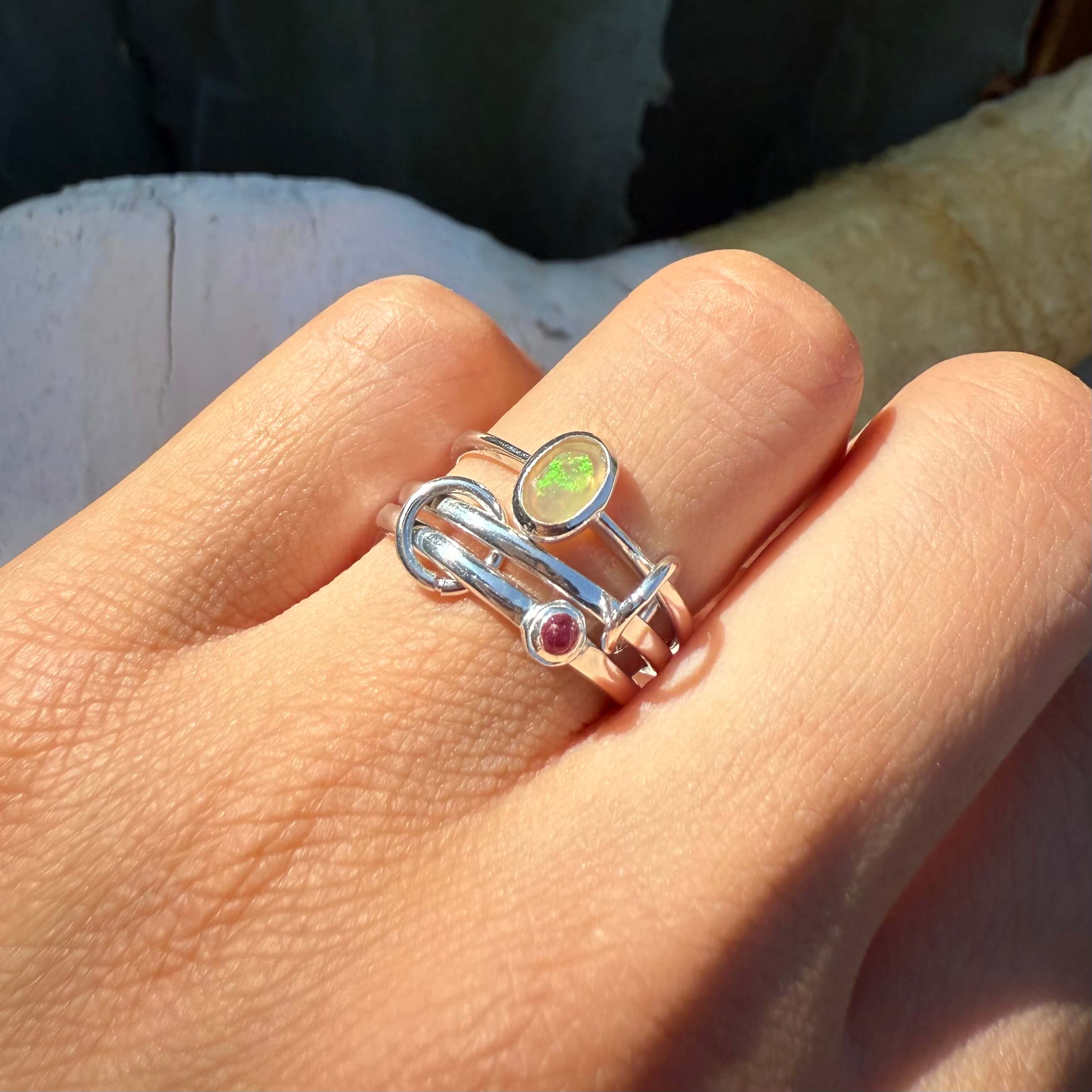 Silver ring with gemstones on a person's finger