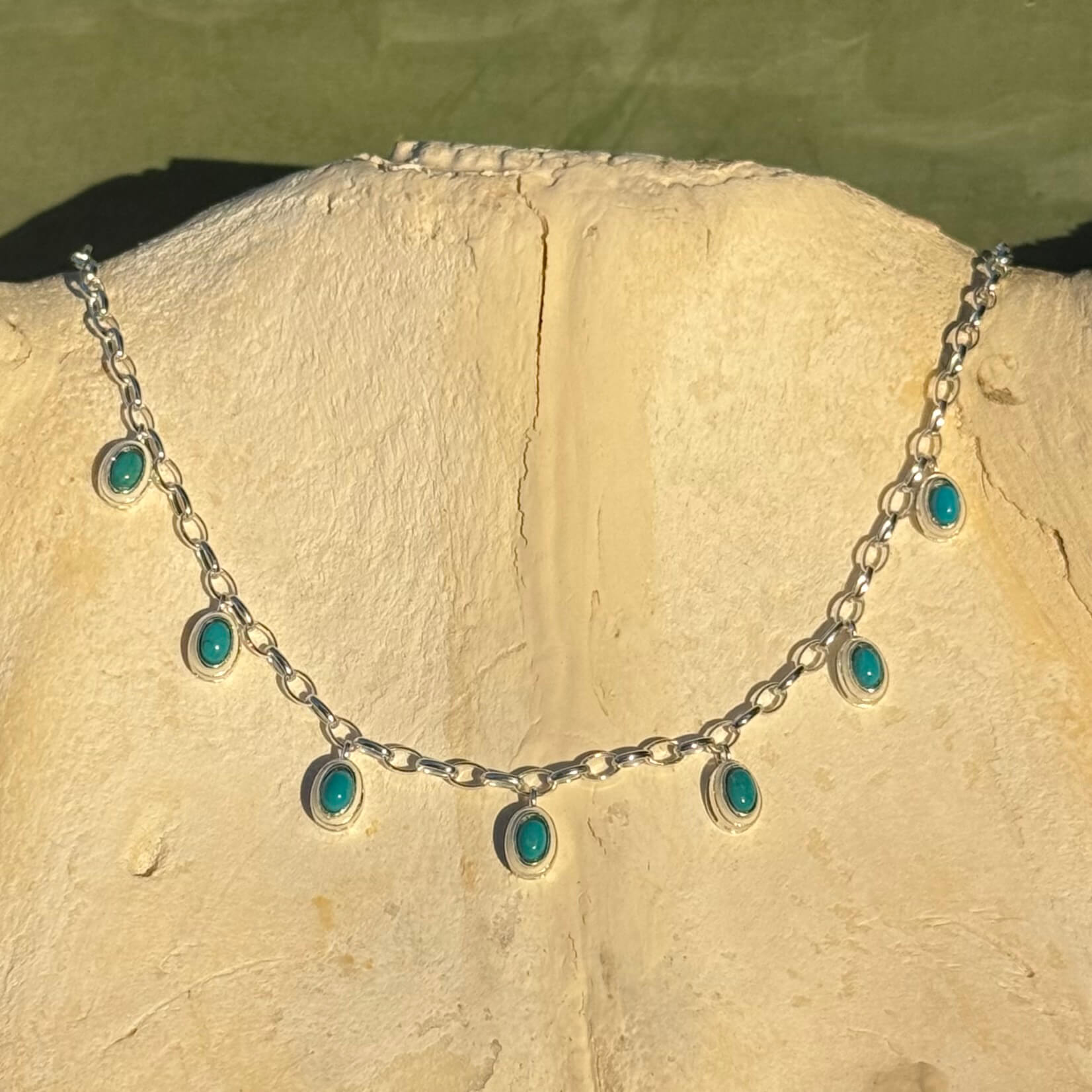 Necklace with turquoise stones on a stone surface